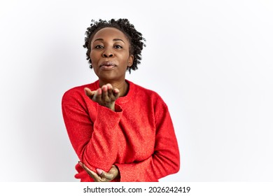 Young african american woman wearing casual clothes over isolated background looking at the camera blowing a kiss with hand on air being lovely and sexy. love expression. 