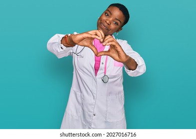 Young African American Woman Wearing Doctor Uniform And Stethoscope Smiling In Love Doing Heart Symbol Shape With Hands. Romantic Concept. 