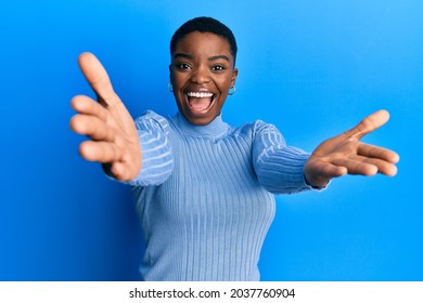 Young african american woman wearing casual clothes looking at the camera smiling with open arms for hug. cheerful expression embracing happiness.  - Shutterstock ID 2037760904