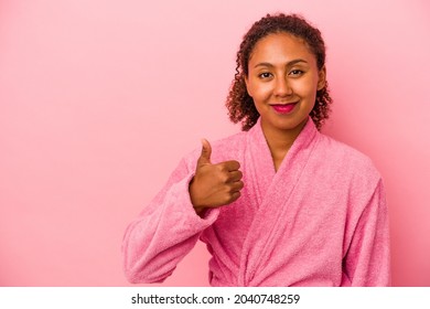 Young african american woman wearing a bathrobe isolated on pink background smiling and raising thumb up - Powered by Shutterstock