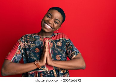 Young African American Woman Wearing African Style Praying With Hands Together Asking For Forgiveness Smiling Confident. 