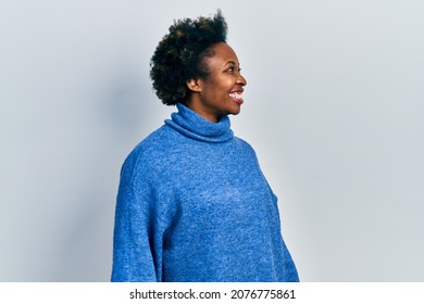 Young african american woman wearing casual clothes looking away to side with smile on face, natural expression. laughing confident. 