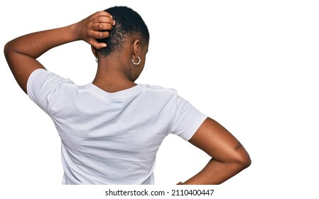 Young African American Woman Wearing Casual White T Shirt Backwards Thinking About Doubt With Hand On Head 