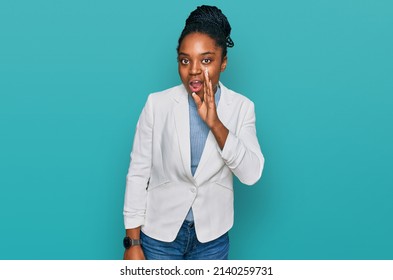 Young african american woman wearing business clothes hand on mouth telling secret rumor, whispering malicious talk conversation 