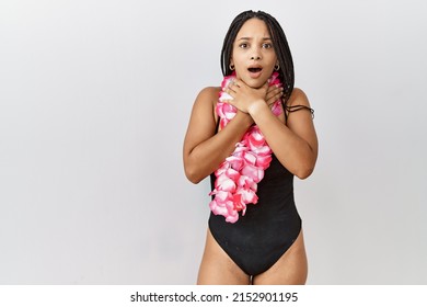Young african american woman wearing swimsuit and hawaiian lei shouting suffocate because painful strangle. health problem. asphyxiate and suicide concept. 