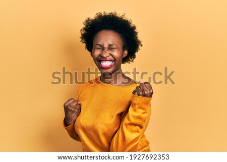 Young african american woman wearing casual clothes celebrating surprised and amazed for success with arms raised and eyes closed. winner concept. 