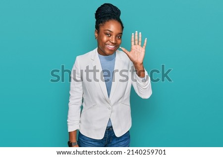 Young african american woman wearing business clothes waiving saying hello happy and smiling, friendly welcome gesture 