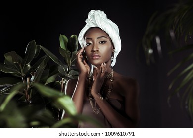 Young African American Woman In White Wire Head Wrap Behind Leaves