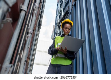 Young African American woman worker at overseas shipping container yard . Logistics supply chain management and international goods export concept . - Shutterstock ID 2066775554