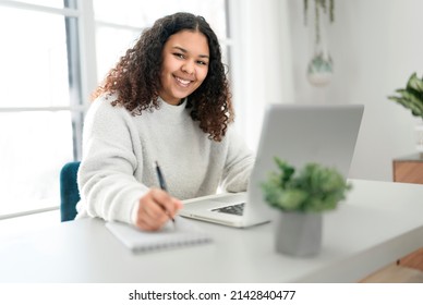 A young African American woman working at laptop at home office