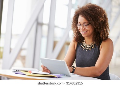 Young African American woman working with tablet in office