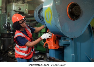 Young african american women worker in safety uniform, hard hat, vest and glove in industrial manufacturer factory are working on heavy machinery. - Powered by Shutterstock