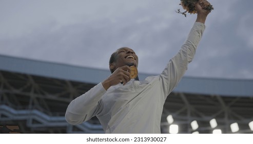 Young African Black male Athlete Celebrates a Win on a podium, receives a gold medal - Powered by Shutterstock