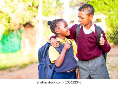 an young african brother with his arm around his younger sister showing positivity with a thumbs up while his younger sister looks up at him in adoration and pride - Powered by Shutterstock