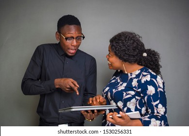 young african business man and woman looking excited while viewing something on a tablet computer