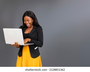 young African business woman holding in hands laptop creating presentation
