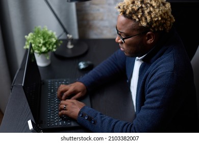 Young African Businessman With An Afro Hairstyle, Working At Home Using A Laptop. An African Businessman Who Works Hard At A Computer Successfully Copes With Remote Work.