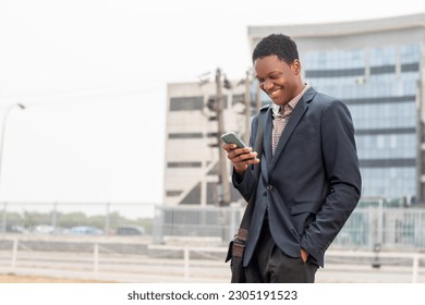 young african businessman smiling while using phone