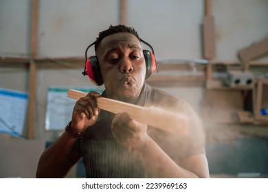 Young African carpenter wood working in factory - Powered by Shutterstock