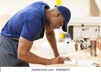 Young African Carpenter Working In Workshop