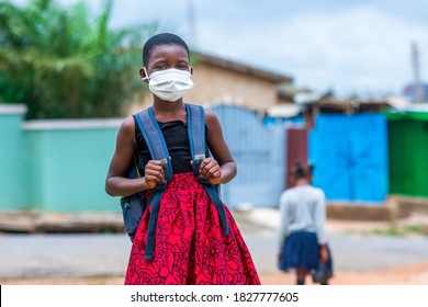 Young African child student in face mask, carrying bag-pack in covid-19 pandemic-concept on education in coronavirus season - Powered by Shutterstock