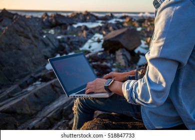 Young African Coloured Man Working On Laptop At The Beach, Cape Town, South Africa