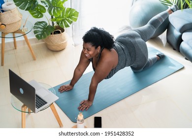 Young African Curvy Woman Doing Pilates Virtual Fitness Class With Laptop At Home - Sport Wellness People Lifestyle Concept