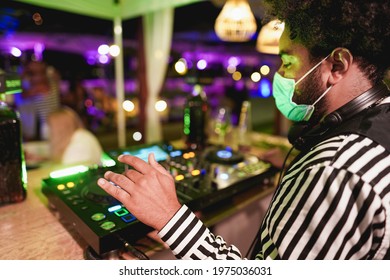 Young African DJ Man Mixing Music At Club Outdoor While Wearing Safety Face Mask For Coronavirus Outbreak