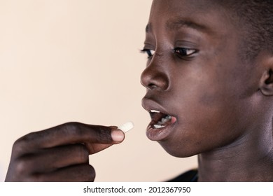 Young African Ethnicity Boy Taking An Oral Medication From A Black Health Professional