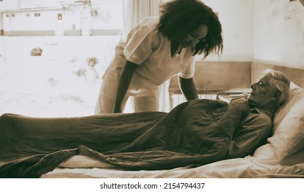 Young African Female Doctor Helping Elderly Retired Man Going To Hospital Bed.