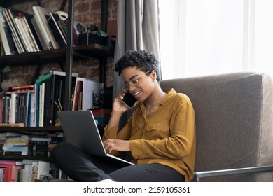 Young African female telemarketer talks to client by cellphone filling order form using laptop, solve business by phonecall. Mobile operator, modern tech usage, remote communication, telework concept - Powered by Shutterstock