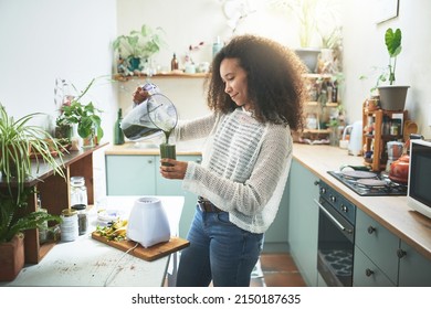 Young african girl preparing her healty smoothie