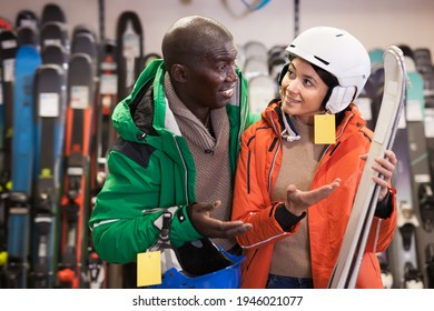 Young African Guy And European Girl Buying Skis In Store