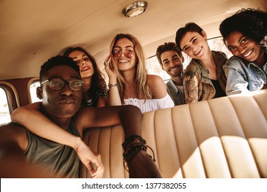 Young African Guy Taking Selfie With Friends Sitting In The Car. Group Of Friends On Road Trip Taking Selfie.