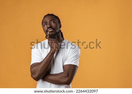 Young african guy thinking about something over yellow background