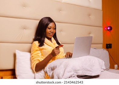 Young African Introvert Woman Using Her Laptop In Bed