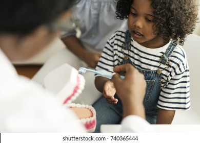 Young African Kid With A Dentist