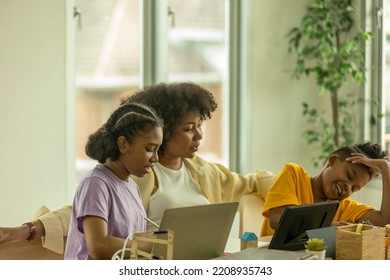 Young African Kids Get Support From A Teacher To Use Tablet For An Online Class. A Class Of African Pupil Taking Online Learning Program Through Computer Notebook.