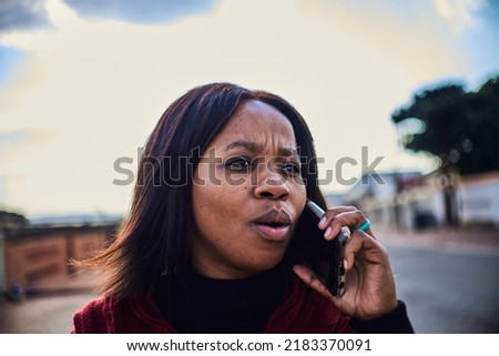 A young african lady is on a phone call with a concerned expression