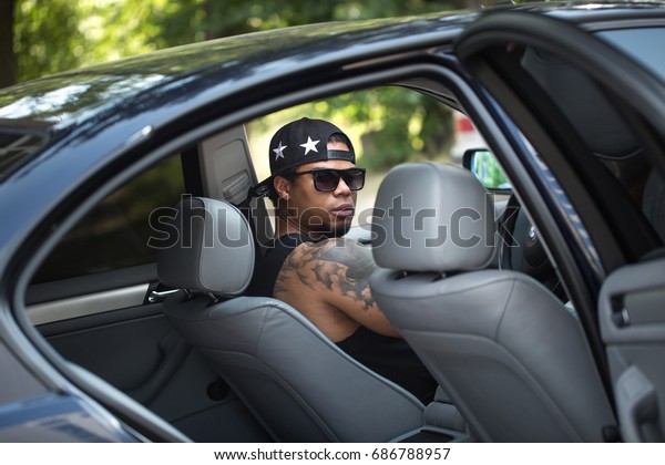 Young african male\
driver driving a car