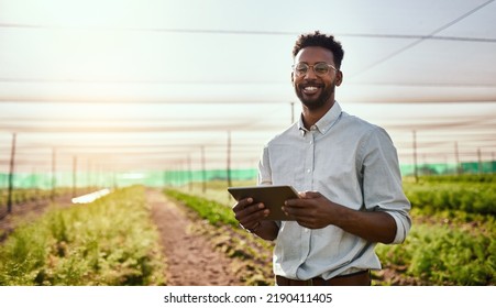 Young African male farmer working on healthy agriculture development strategy on his digital tablet. Smiling field worker outdoors on organic farming and growth sustainability check up - Shutterstock ID 2190411405