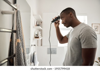 Young African Man Cutting His Hair In His Bathroom