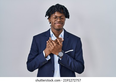 Young african man with dreadlocks wearing business jacket over white background smiling with hands on chest with closed eyes and grateful gesture on face. health concept.  - Shutterstock ID 2191272757