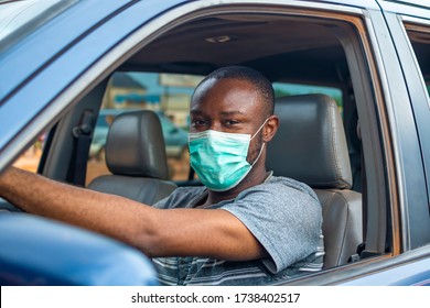 Young African Man Driving A Car Wearing A Face Mask