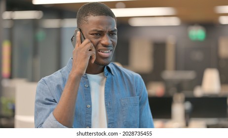 Young African Man Getting Angry On Phone Call 