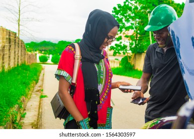 Young African Man Making A Contactless Payment With A Beautiful Woman After Fixing A Car