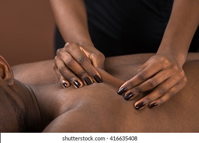 Young African Man Receiving Back Massage At Spa