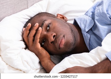 Young African Man Suffering From Fever Lying On Bed