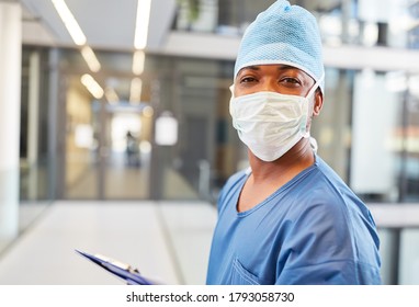 Young African man as a surgeon with surgical mask in front of the emergency department of the clinic