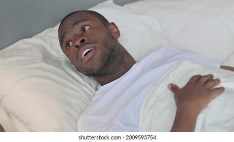 Young African Man Waking Up From Nightmare In Bed 